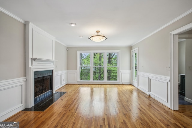 4284 Windy Gap Ct NW, Kennesaw, GA 30144 - unfurnished living room with a decorative wall, crown molding, wood finished floors, a large fireplace, and a wainscoted wall