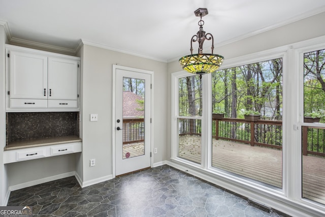 4284 Windy Gap Ct NW, Kennesaw, GA 30144 - doorway to outside with stone finish floor, built in study area, ornamental molding, and a wealth of natural light