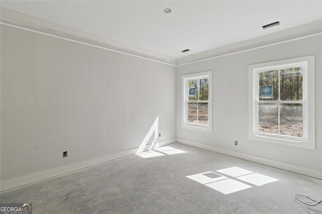 unfurnished room featuring concrete flooring, visible vents, baseboards, and ornamental molding