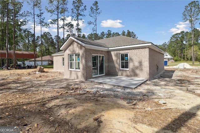 rear view of house featuring a patio and brick siding