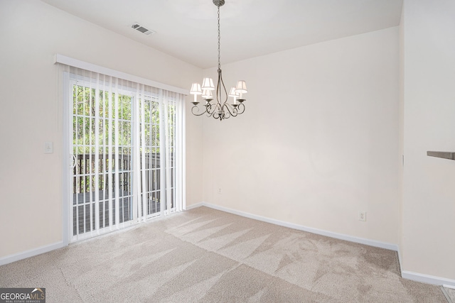 carpeted spare room with visible vents, baseboards, and a chandelier