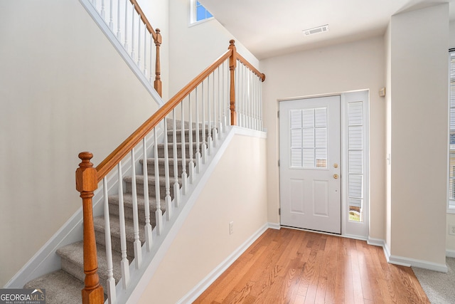 entryway featuring visible vents, baseboards, hardwood / wood-style floors, and stairway