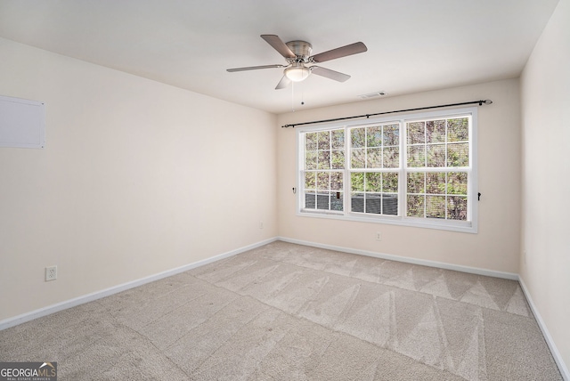 spare room featuring visible vents, a ceiling fan, baseboards, and carpet floors