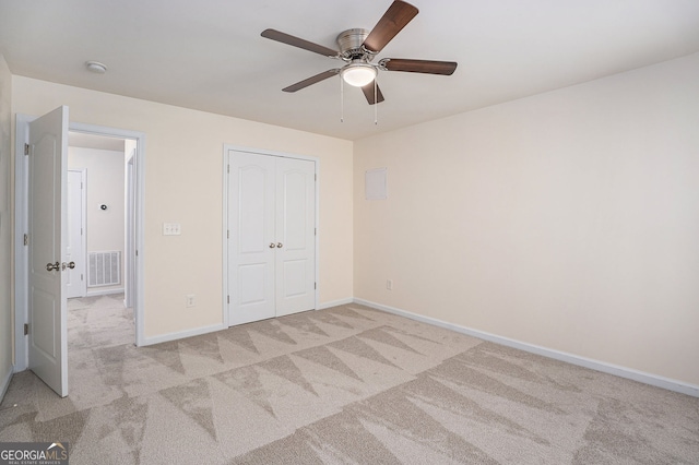 unfurnished bedroom with baseboards, visible vents, a closet, and light colored carpet