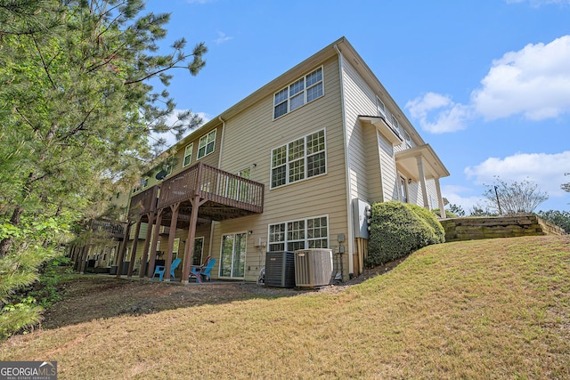back of property with a lawn, central AC unit, and a wooden deck