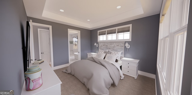bedroom featuring light carpet, baseboards, connected bathroom, and a raised ceiling