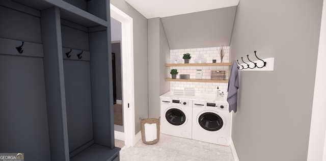 laundry area featuring tile patterned floors, washing machine and clothes dryer, baseboards, and laundry area