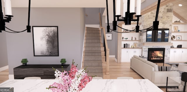 living room with stairway, baseboards, light wood finished floors, and a fireplace