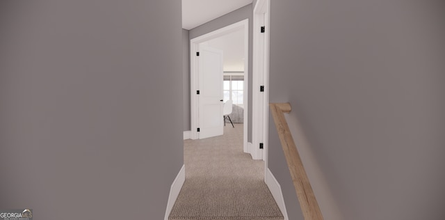 hall featuring light carpet, baseboards, and an upstairs landing