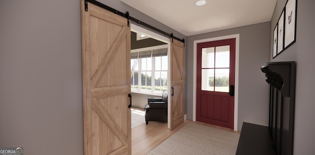 doorway featuring a barn door and light wood-type flooring