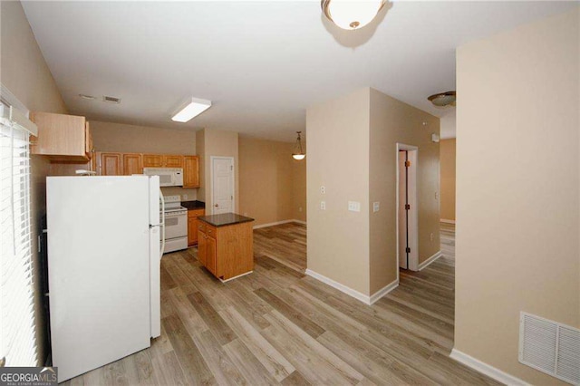 kitchen with visible vents, baseboards, light wood-type flooring, white appliances, and a kitchen island