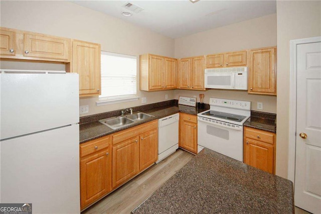 kitchen with a sink, white appliances, visible vents, and dark countertops
