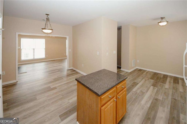 kitchen with open floor plan, light wood-style flooring, and baseboards