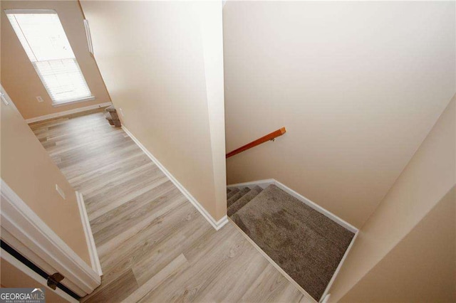 staircase featuring baseboards and wood finished floors