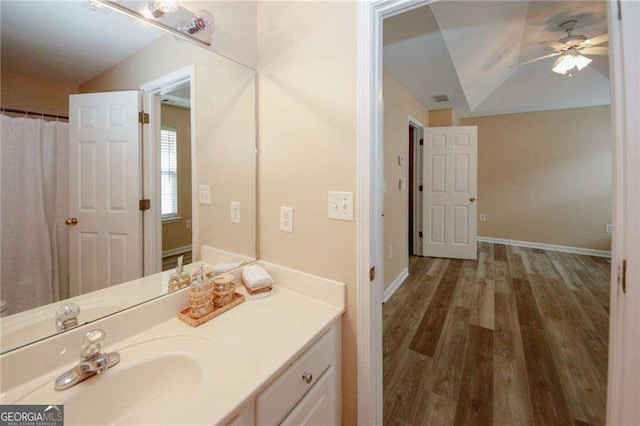 bathroom featuring wood finished floors, vanity, ceiling fan, and vaulted ceiling