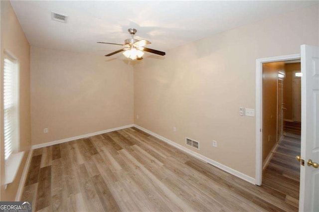 empty room with visible vents, baseboards, a ceiling fan, and light wood-style floors
