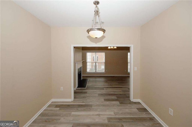 hall with baseboards and wood finished floors