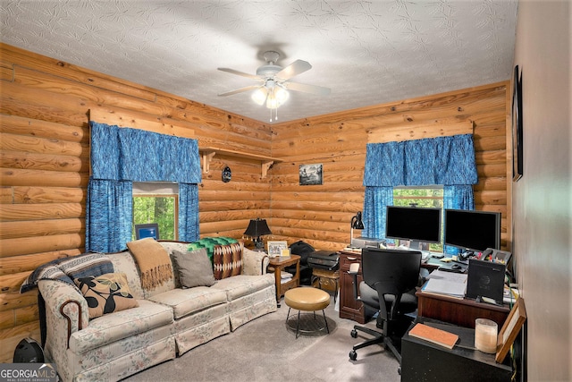 carpeted office featuring rustic walls and a ceiling fan