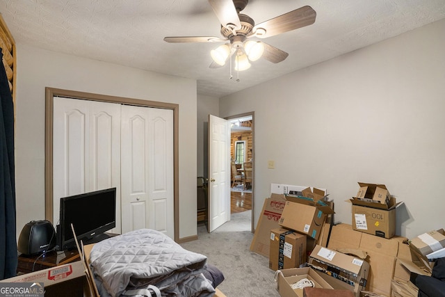 bedroom featuring light colored carpet, a closet, and ceiling fan