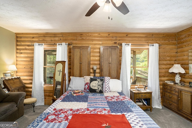 bedroom with ceiling fan, carpet, access to exterior, and log walls