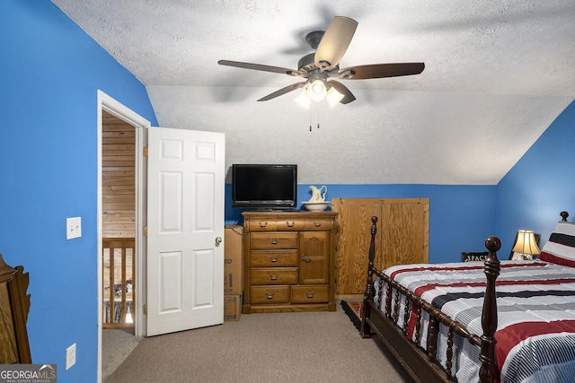 bedroom with vaulted ceiling, a textured ceiling, and carpet flooring