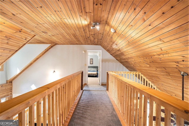 hall with carpet floors, an upstairs landing, wooden ceiling, and vaulted ceiling