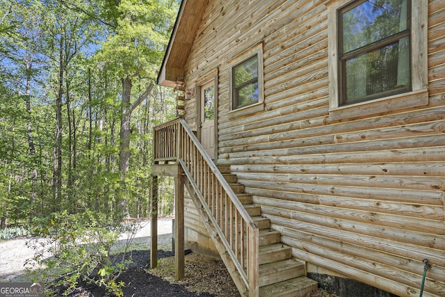view of side of property featuring log siding and stairs