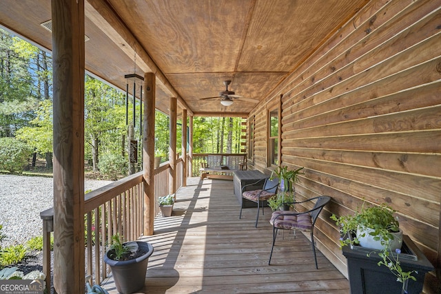 wooden terrace featuring covered porch and ceiling fan