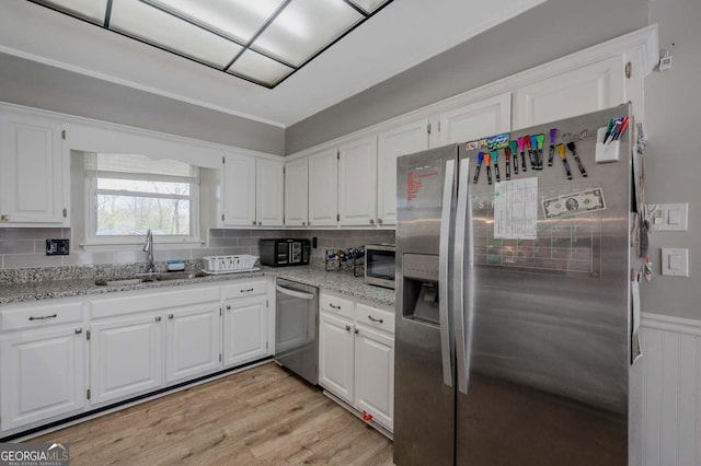 182 Hickory Dr, Ringgold, GA 30736 - kitchen with light stone countertops, light wood-style flooring, white cabinets, stainless steel appliances, and decorative backsplash