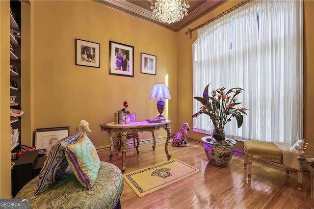 office space with a chandelier, ornamental molding, and wood finished floors
