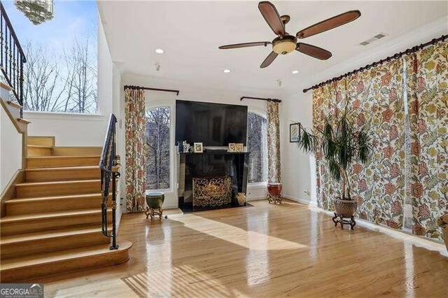 unfurnished living room with recessed lighting, stairway, visible vents, ceiling fan, and wood finished floors