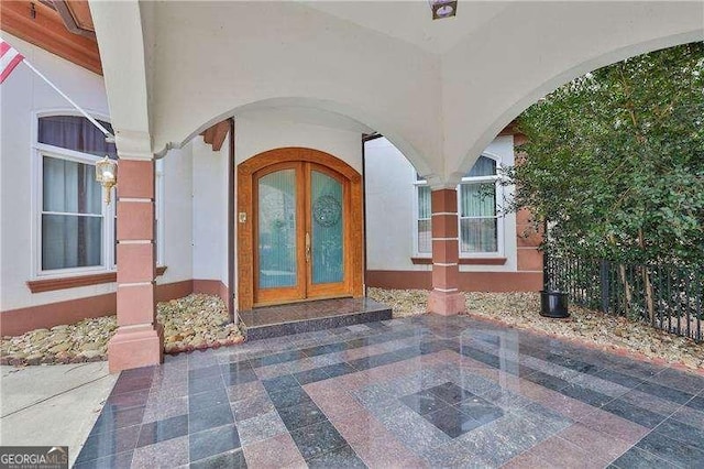 view of exterior entry with french doors and stucco siding