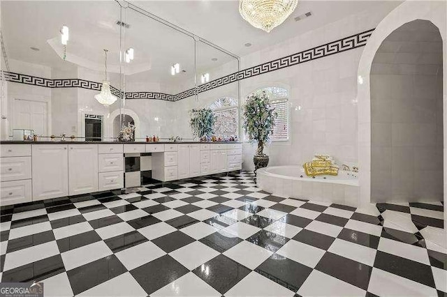 bathroom with tile patterned floors, a garden tub, vanity, and visible vents