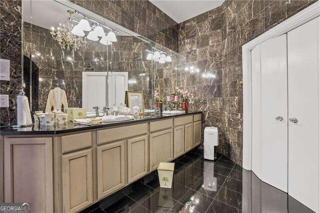bathroom with a sink, tile walls, and double vanity