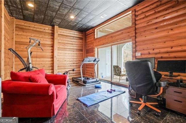 office space with wooden walls, recessed lighting, granite finish floor, and a high ceiling
