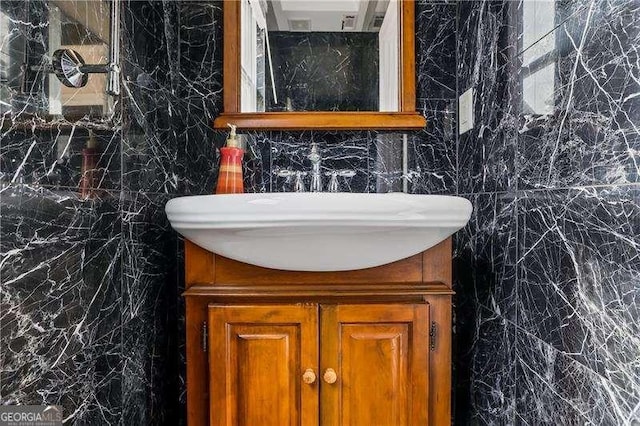 bathroom with vanity and tile walls