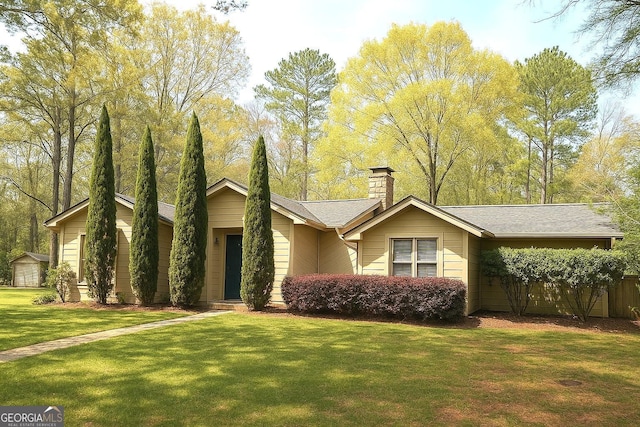 view of front facade with a chimney and a front lawn