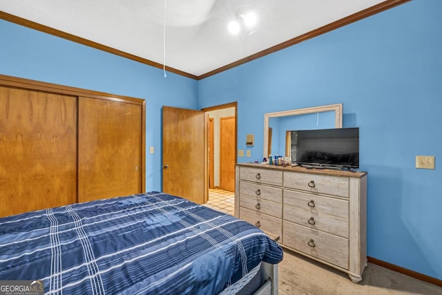 bedroom featuring crown molding, baseboards, and a closet