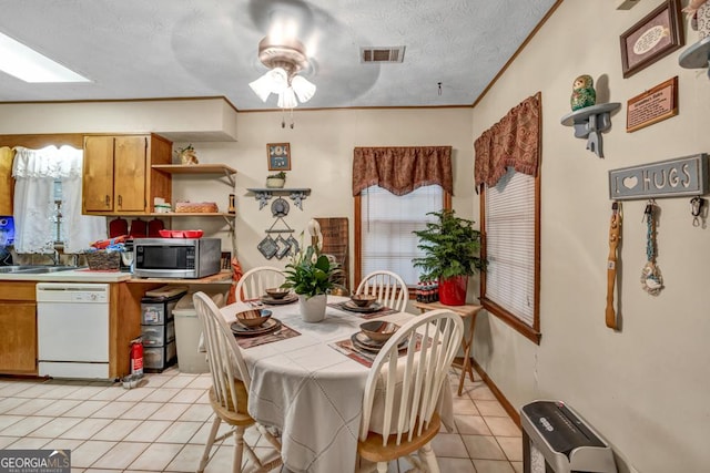 dining space featuring light tile patterned floors, a ceiling fan, healthy amount of natural light, and ornamental molding