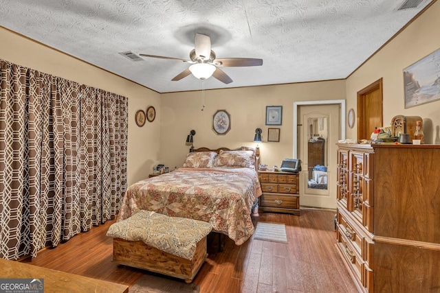 bedroom featuring hardwood / wood-style flooring, a textured ceiling, and ceiling fan