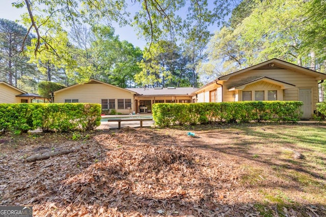 rear view of property featuring a swimming pool