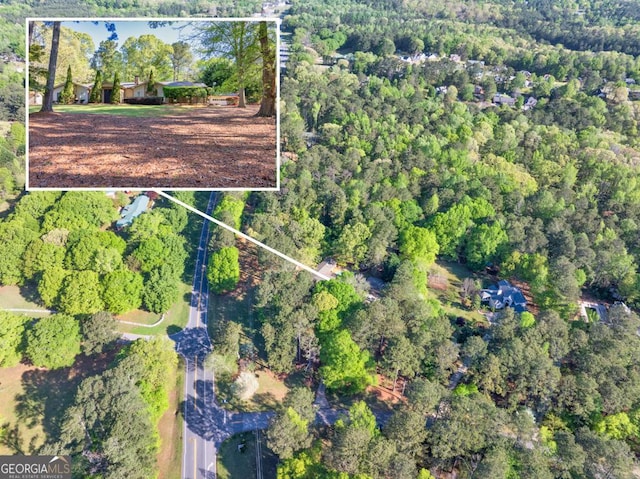 aerial view of property and surrounding area with a forest