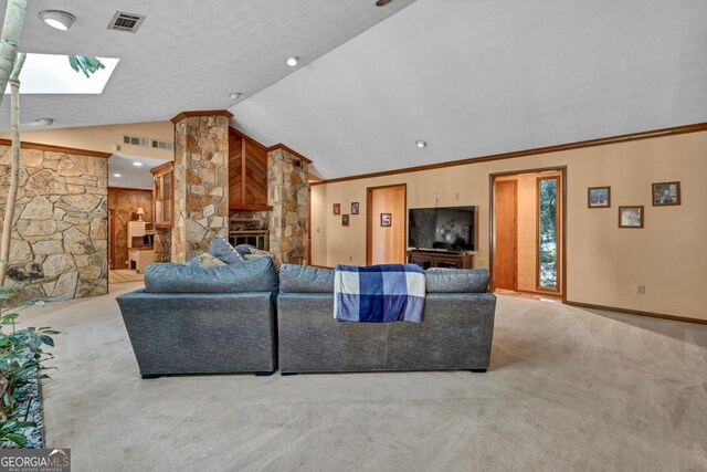 living area with carpet, a glass covered fireplace, a skylight, vaulted ceiling, and baseboards