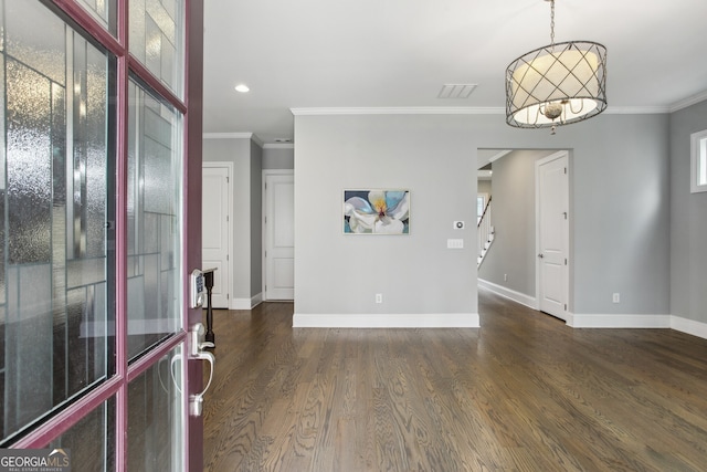entryway with visible vents, baseboards, crown molding, and wood finished floors