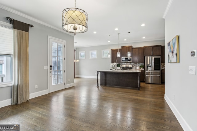 kitchen with stainless steel appliances, dark wood-style flooring, ornamental molding, and dark brown cabinets