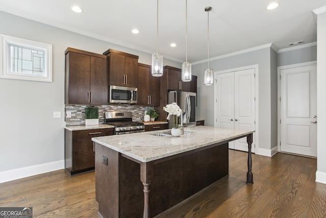 kitchen featuring a center island with sink, appliances with stainless steel finishes, dark brown cabinets, and dark wood finished floors