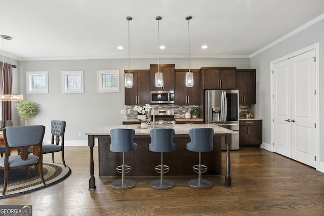 kitchen with tasteful backsplash, a kitchen bar, crown molding, stainless steel appliances, and dark wood-type flooring