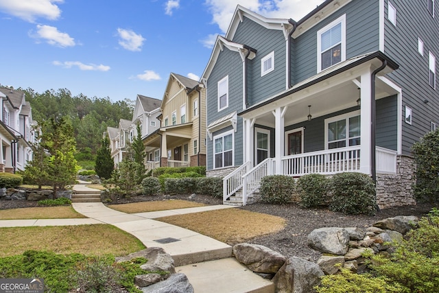 view of front of house featuring a residential view, stone siding, and covered porch