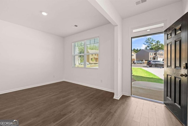 unfurnished room with baseboards, dark wood-style floors, and plenty of natural light