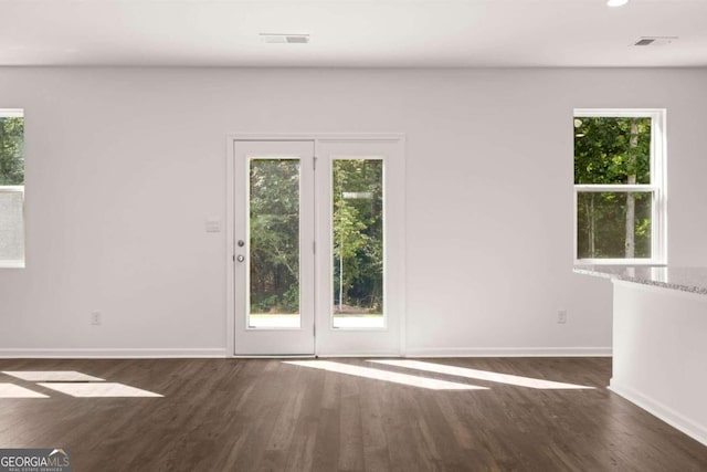 unfurnished living room featuring visible vents, a ceiling fan, baseboards, and dark wood-style flooring